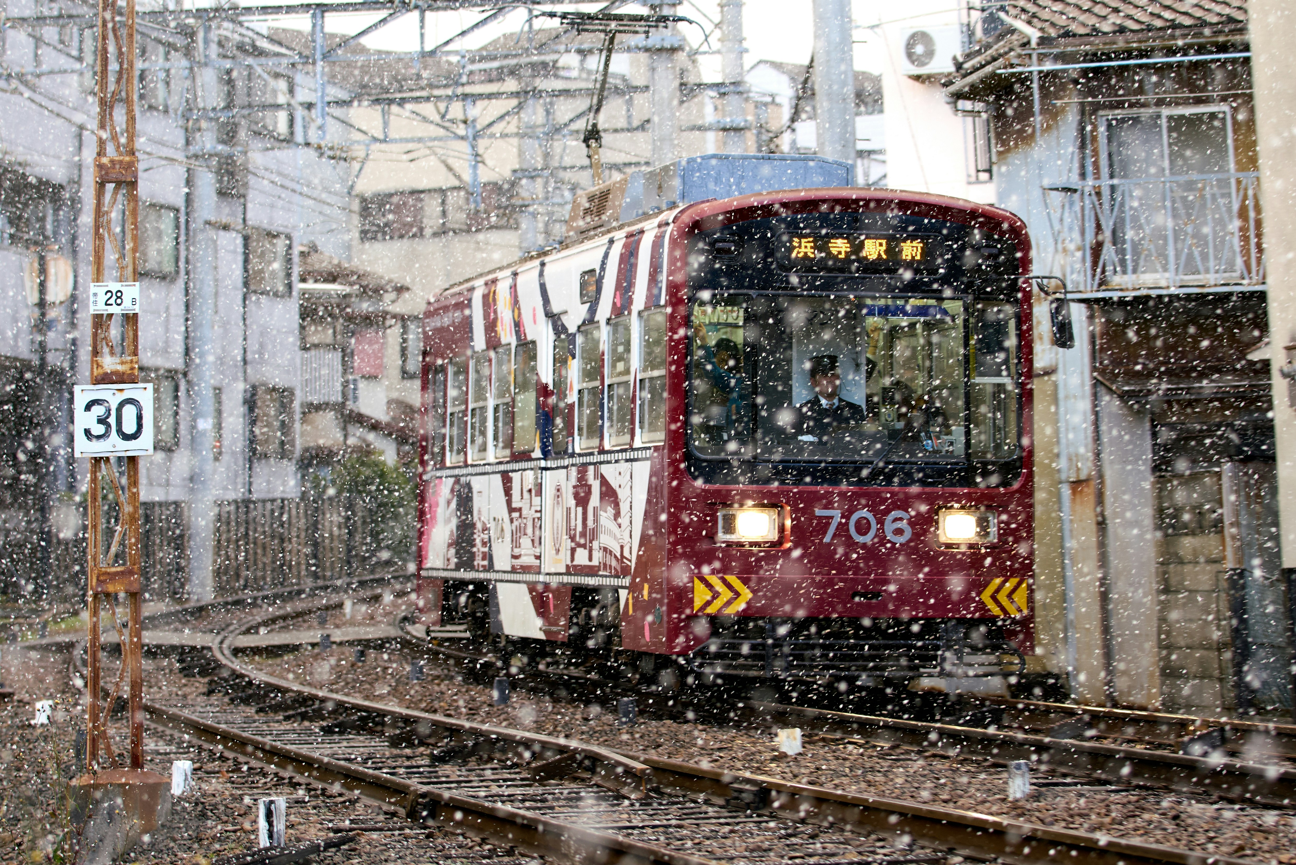 白背景の上に衣類や小物が整然と並び、スマホで撮影している手元の様子